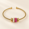 Gold-toned open cuff bracelet with pink, white and gold-toned cylindrical beadwork
