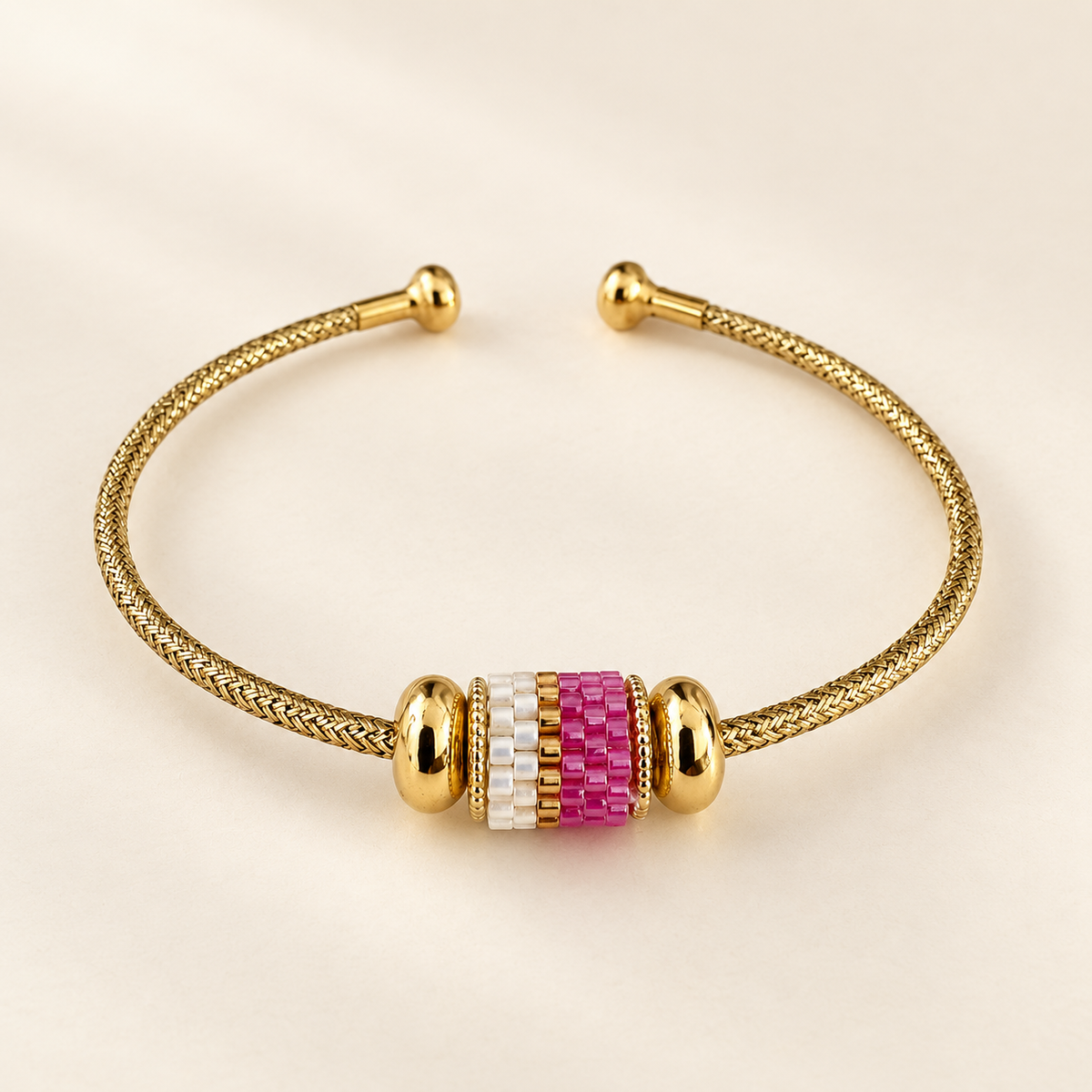Gold-toned open cuff bracelet with pink, white and gold-toned cylindrical beadwork