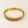 Gold-toned bangle with intricate white, champagne and warm metallic beadwork