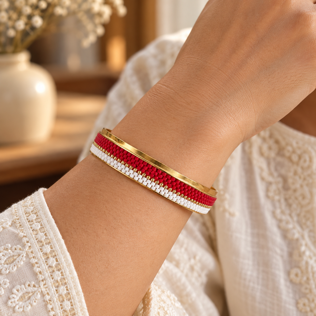 Gold-toned bangle with scarlet red and white beadwork and a fine gold-toned line — styled view