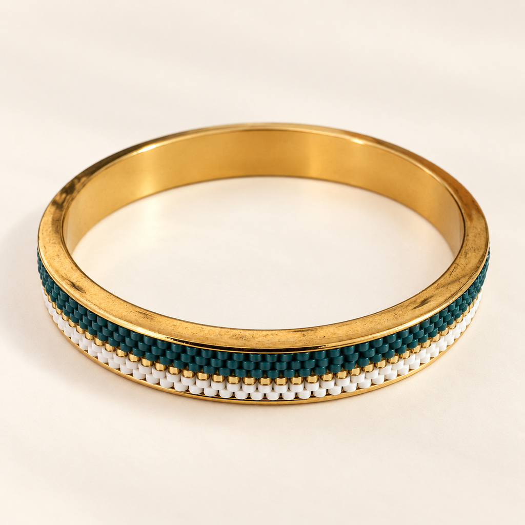 Gold-toned bangle with deep teal, white and gold-toned beadwork